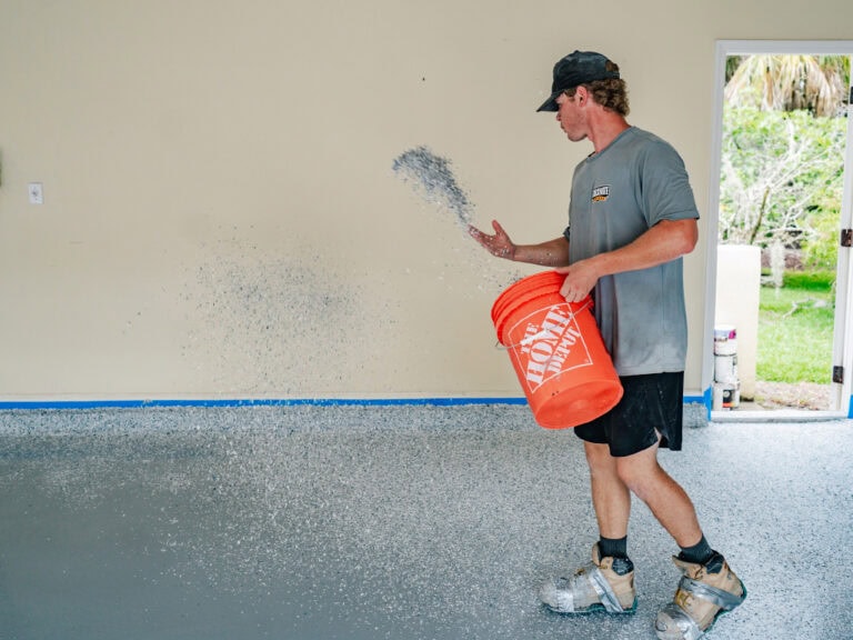 Freshly coated garage floor with epoxy resin by Checkmate Coatings, showcasing professional concrete floor coating services for durable and attractive finishes.