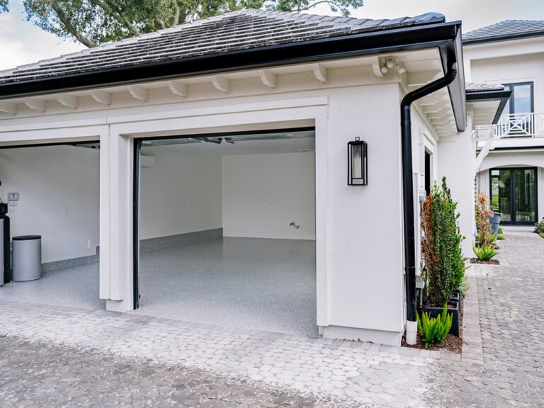 High-quality garage with newly coated epoxy flooring by Checkmate Coatings, providing durability and aesthetic appeal. Expert residential and commercial coating services for long-lasting protection.