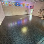 Garage gym with colorful neon signs and American flag, featuring a polished polyaspartic floor and gym equipment in Jacksonville.