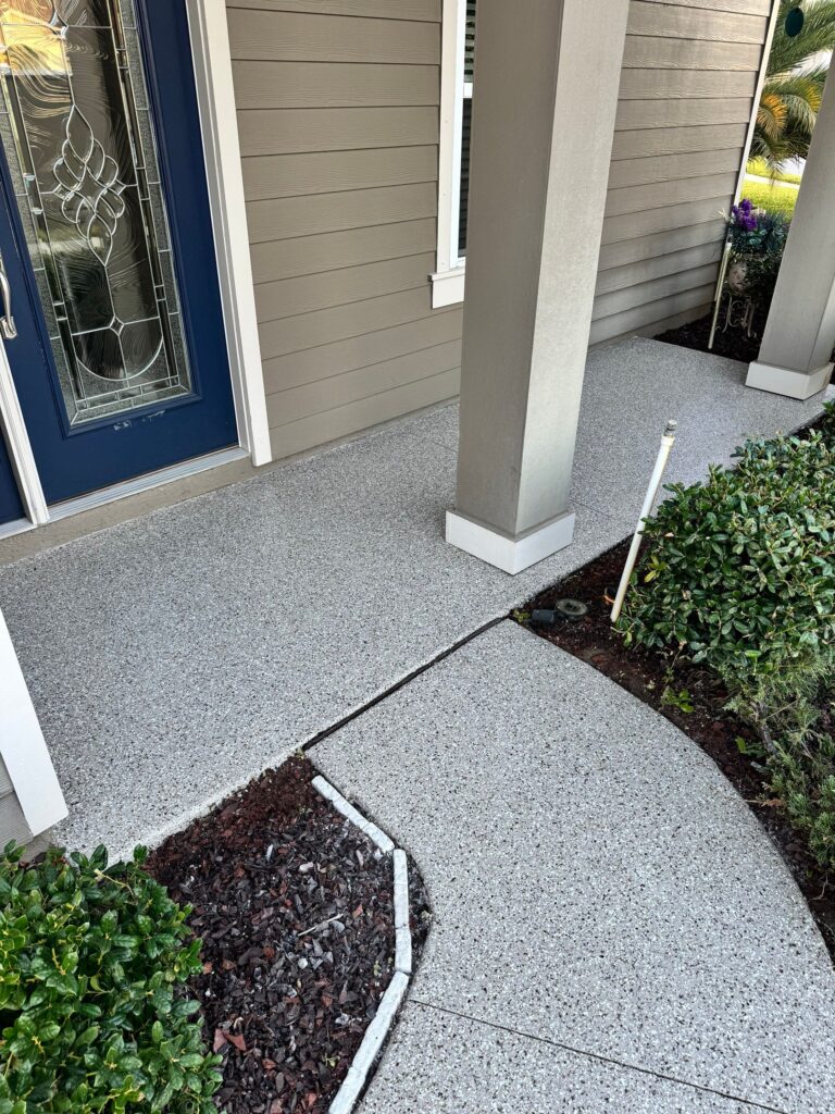 Newly coated concrete porch and walkway with decorative border at a residential home.
