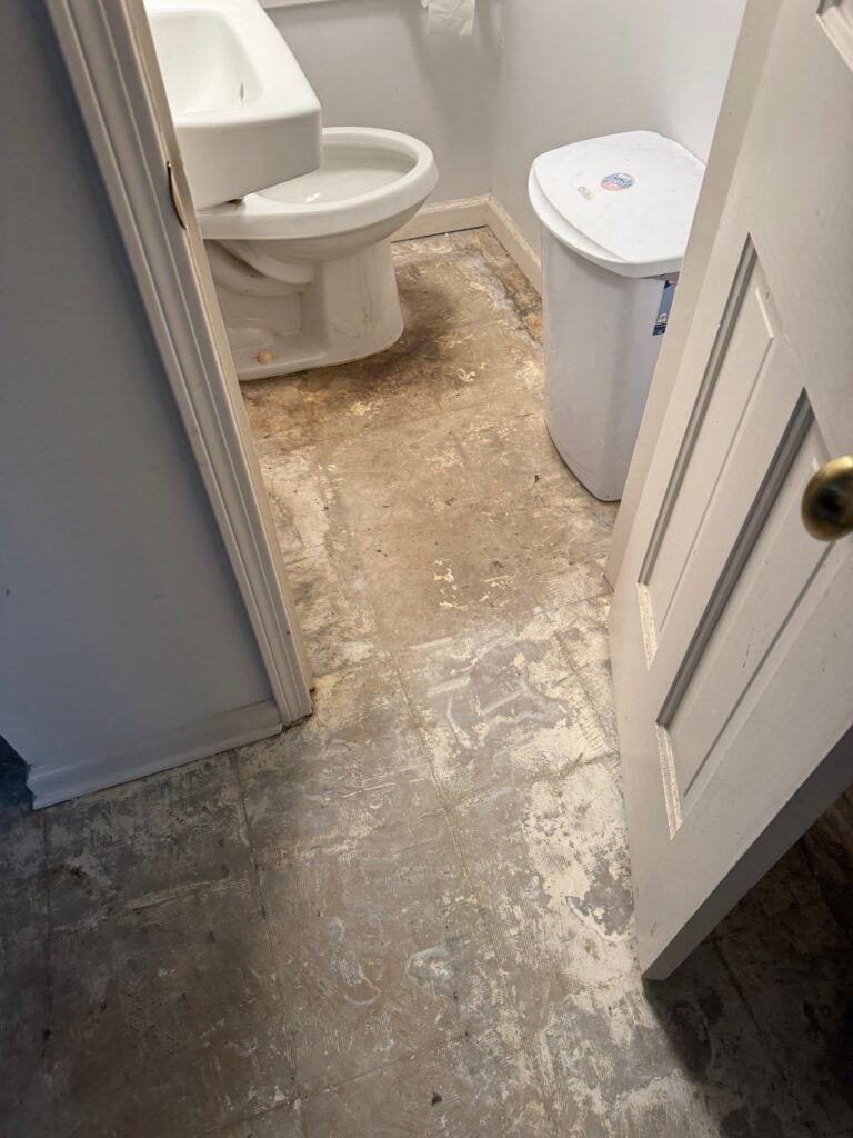 Before garage floor coating renovation in , showing worn concrete with stains and damage.