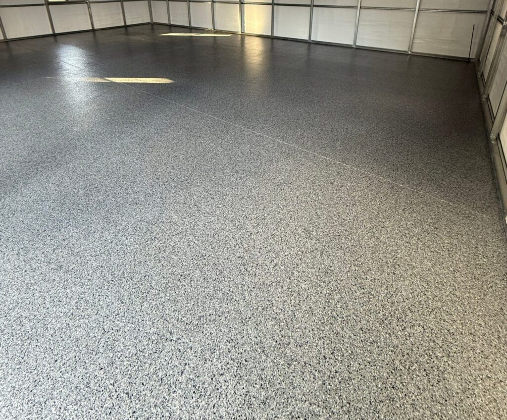 Garage floor coated with durable, textured epoxy finish in a well-lit garage space.