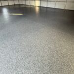Garage floor coated with durable, textured polyaspartic finish in a well-lit garage space.