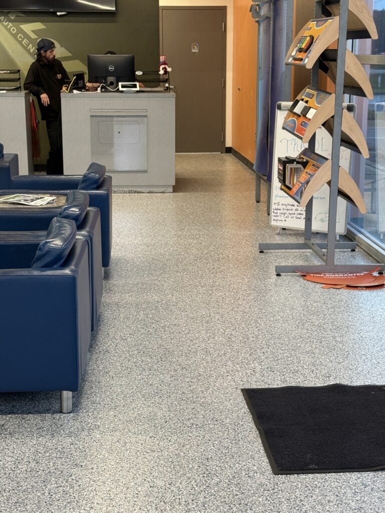 Interior view of Quick Lane Tire & Auto Center at Murray Ford of Kingsland showing reception desk, seating area, and display rack with automotive products.