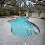 Beautiful backyard pool with stonewash deck and screened enclosure, perfect for outdoor relaxation and entertainment.