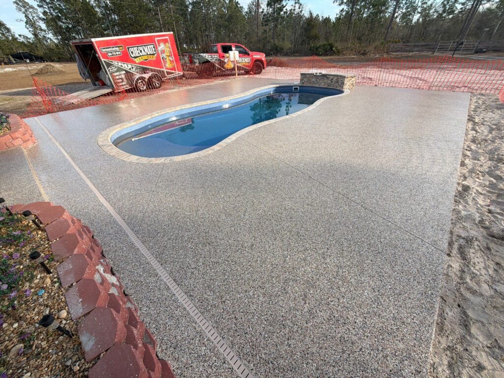 Newly coated pool deck with textured, slip-resistant surface at a residential property.