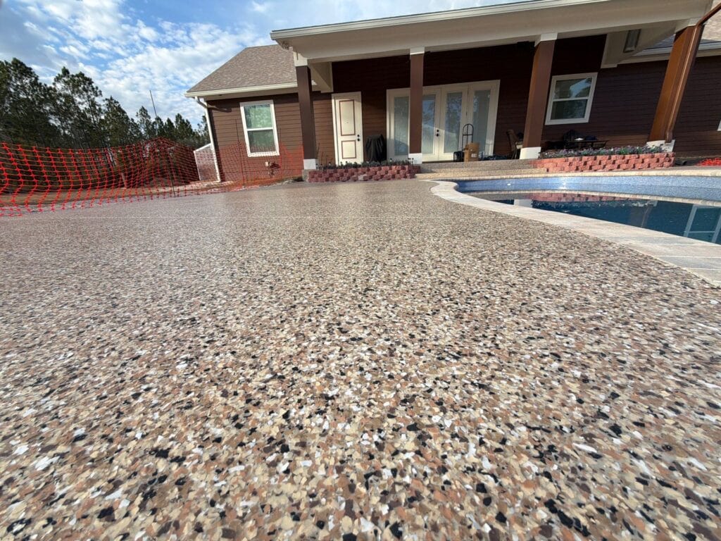 Close-up of a textured, durable concrete pool deck with a speckled finish, ideal for outdoor pool areas and enhancing backyard aesthetics.