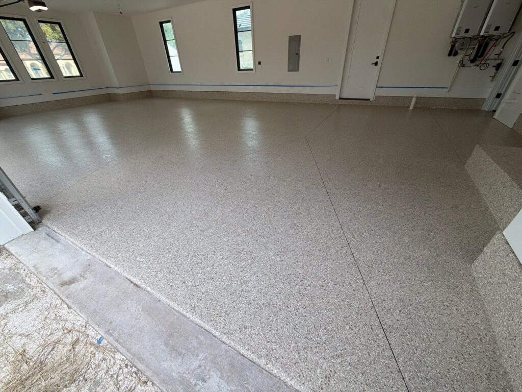 Finished garage floor transformation by Checkmate Coatings featuring a durable polyaspartic coating system designed for long-lasting performance and a clean, professional appearance. Our garage floor coatings use full-broadcast decorative flake with a high-performance polyaspartic system.