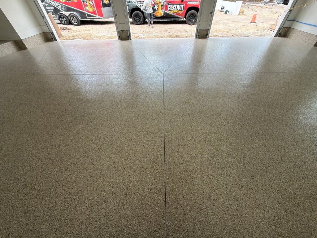 Polished polyaspartic garage floor with a seamless finish and decorative speckled appearance, ideal for durable and attractive garage coatings.