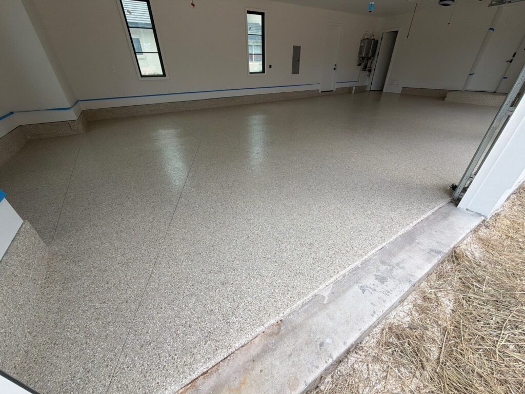 Newly coated garage floor with durable polyaspartic finish in a residential space.