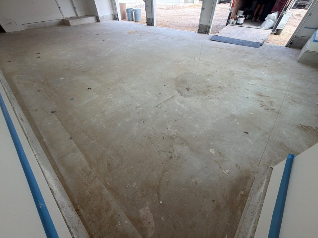 Unfinished garage floor with concrete surface, ready for coating, in a residential garage space.