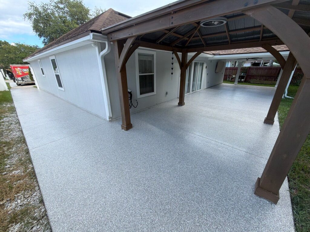 Back patio and walkway with new epoxy coating in Stony Creek, featuring a covered area with wooden beams and a smooth, durable surface.