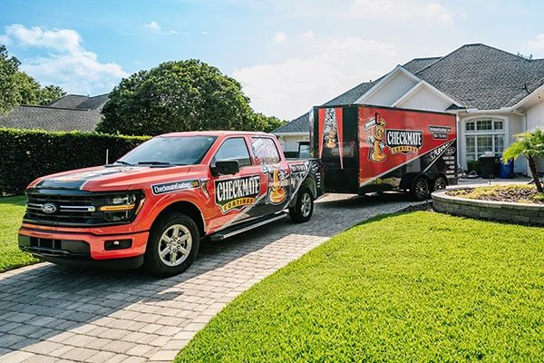 Checkmate Coatings mobile service truck parked in a residential driveway, offering professional coating solutions for homes and surfaces.